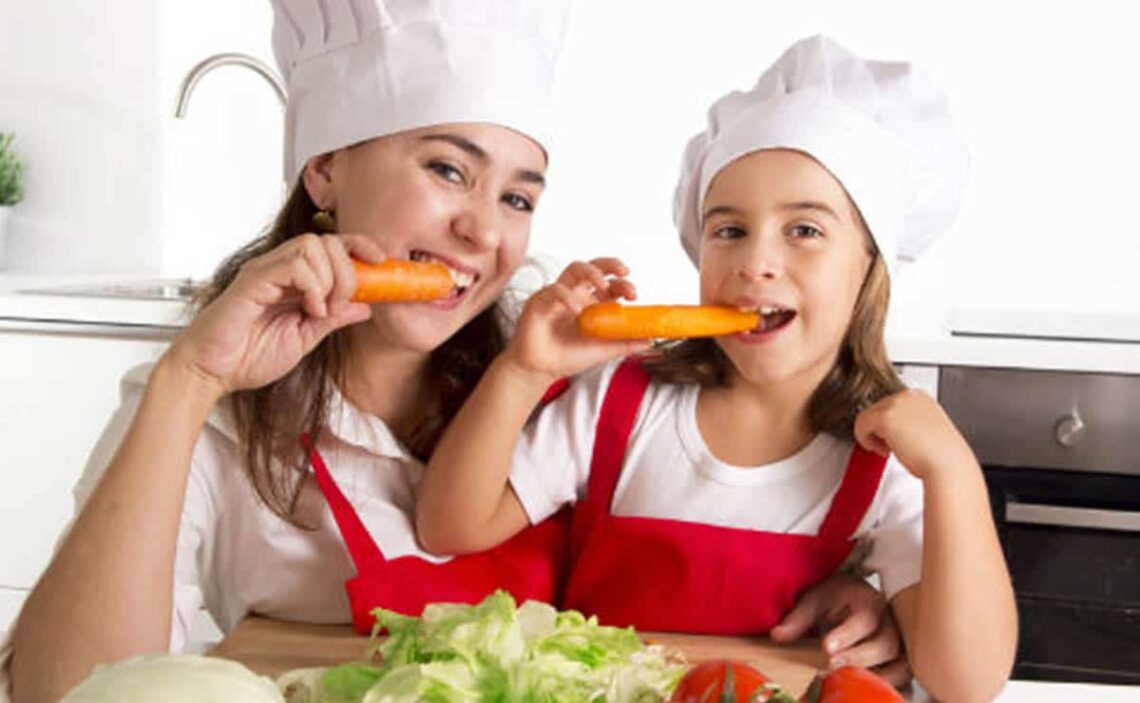 Madre e hija comiendo zanahoria