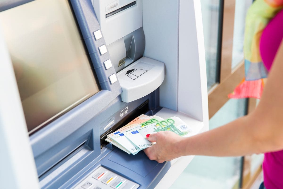 Mujer sacando dinero en efectivo del cajero automático