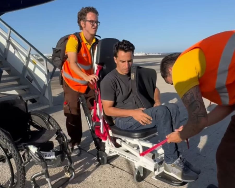 Pablo Tovar, en silla de ruedas, sube por las escaleras de un avión