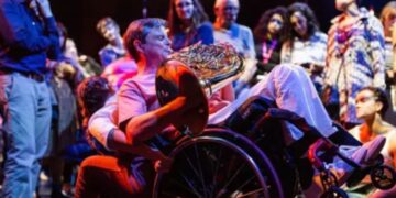 Persona usuaria en silla de ruedas de la orquesta inclusiva